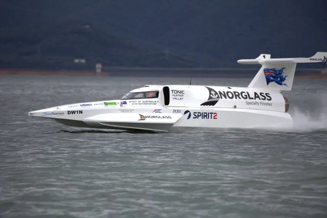 The Spirit of Australia II speed boat racing side-on across a lake, with Norglass branding along its hull and tail.